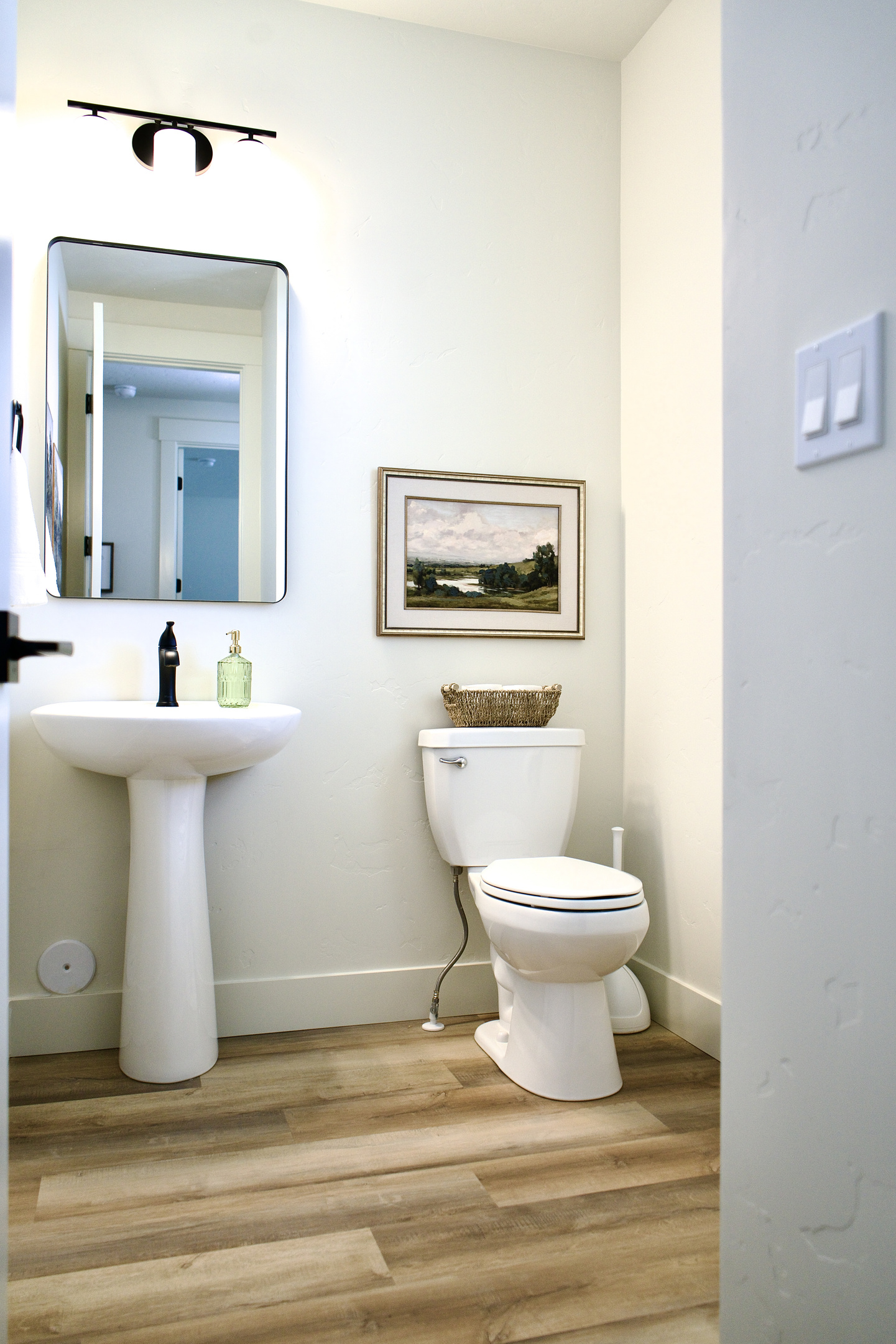The spacious downstairs half bathroom features modern finishes and a thoughtfully designed layout, providing added convenience and comfort for guests.