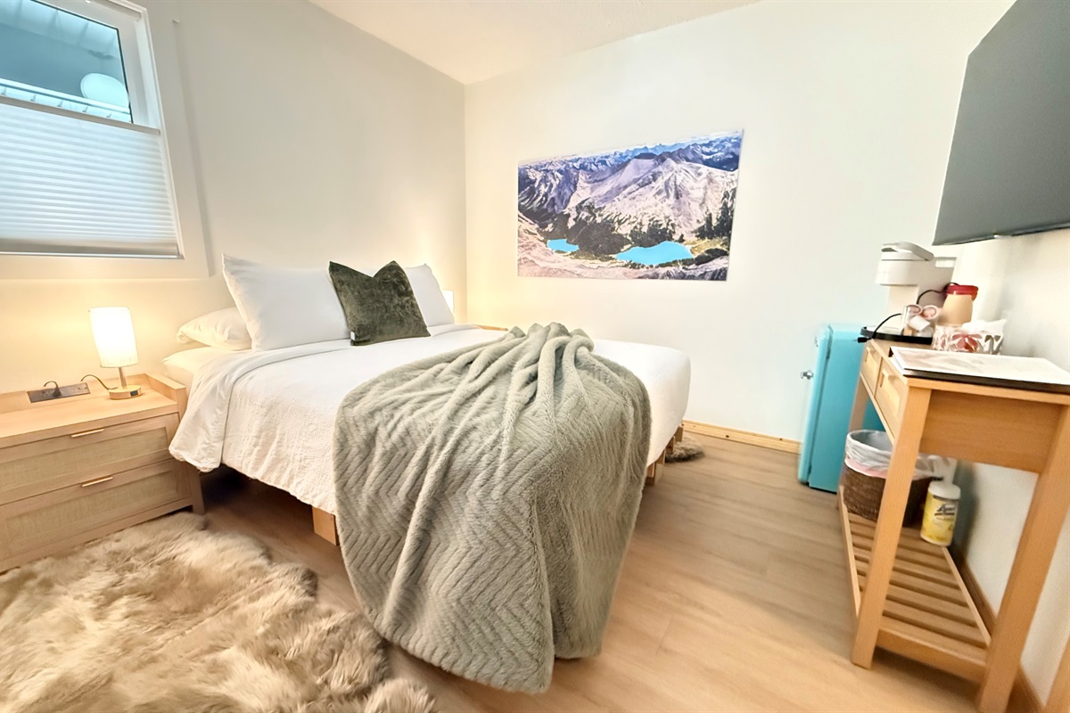Cozy Main Floor Bedroom: A restful bedroom featuring a 55-inch Smart TV and electric fireplace.