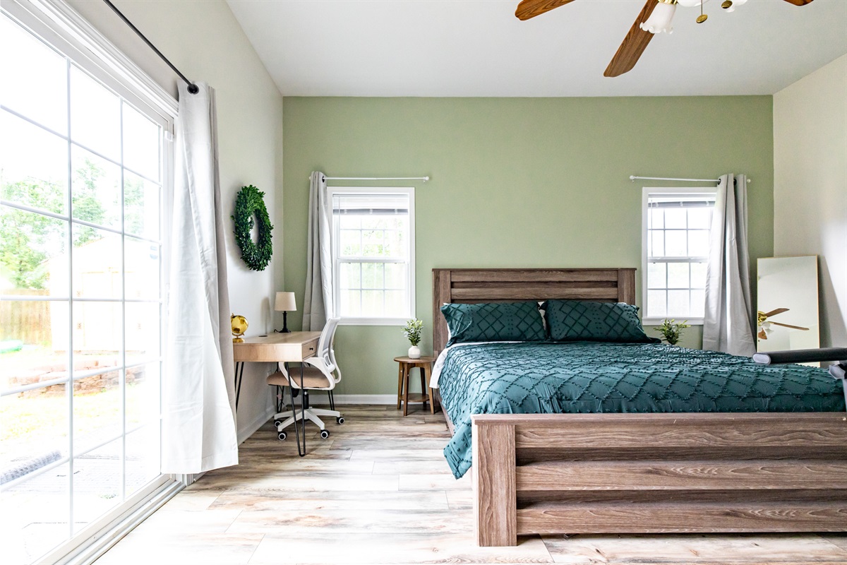 Bedroom 3: King bed with desk, TV, blackout curtains, and fitness equipment