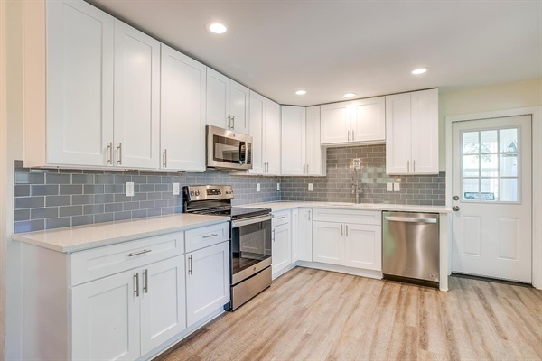 Open-concept kitchen with updated cabinetry, stainless steel appliances, and plenty of prep space for group meals.