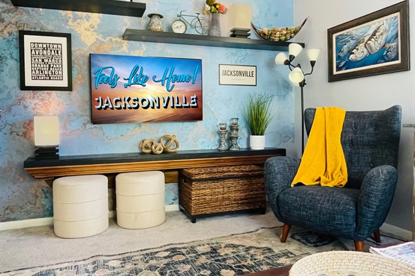 Living Rm: 65” TV, lamps, 2 stools, large chair & wicker box of board games