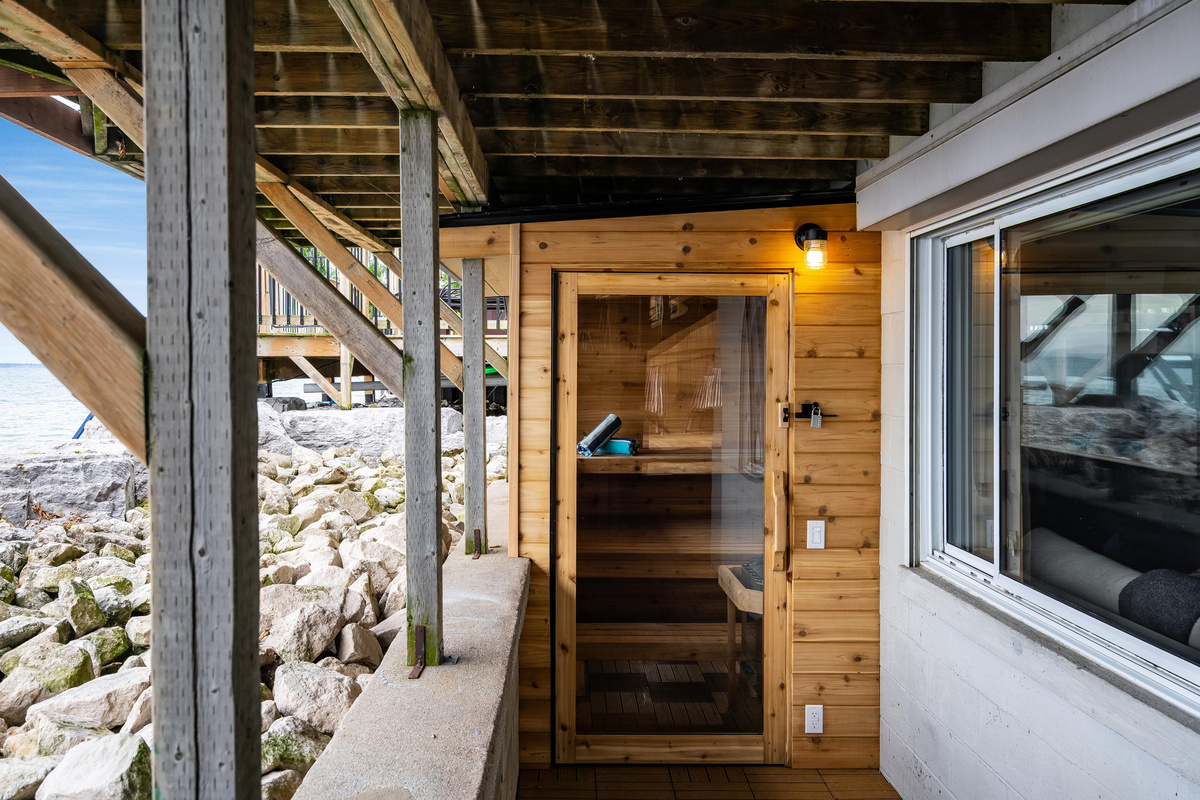 Cedar sauna with a covered walkway and lake views.