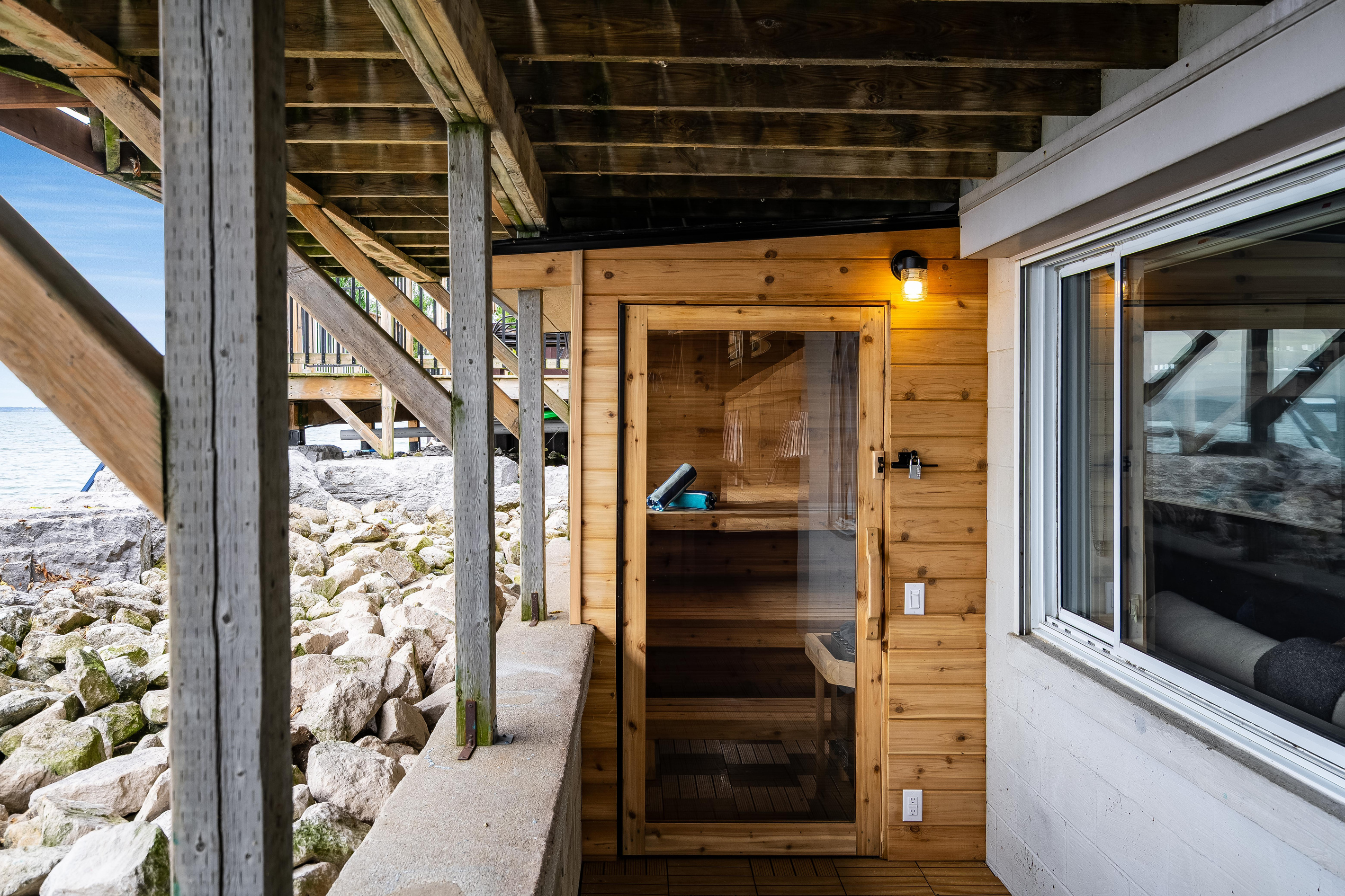 Cedar sauna with a covered walkway and lake views.