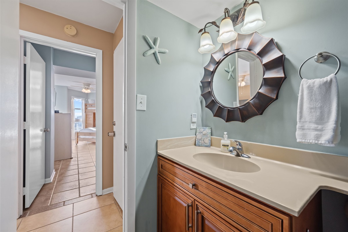 Hallway bathroom vanity with ample counter space, coastal d&eacute;cor, and easy access from the main living areas