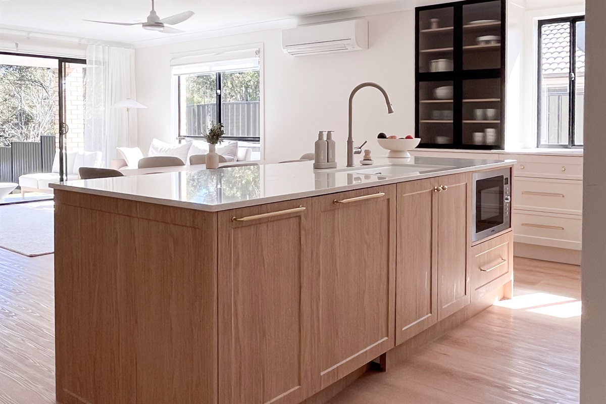 The kitchen island adds broad bench space, storage, an integrated sink and easy flow into the open-plan living area.