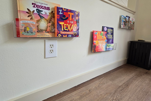 Third bedroom with kids' books on the wall and toys in the closet.