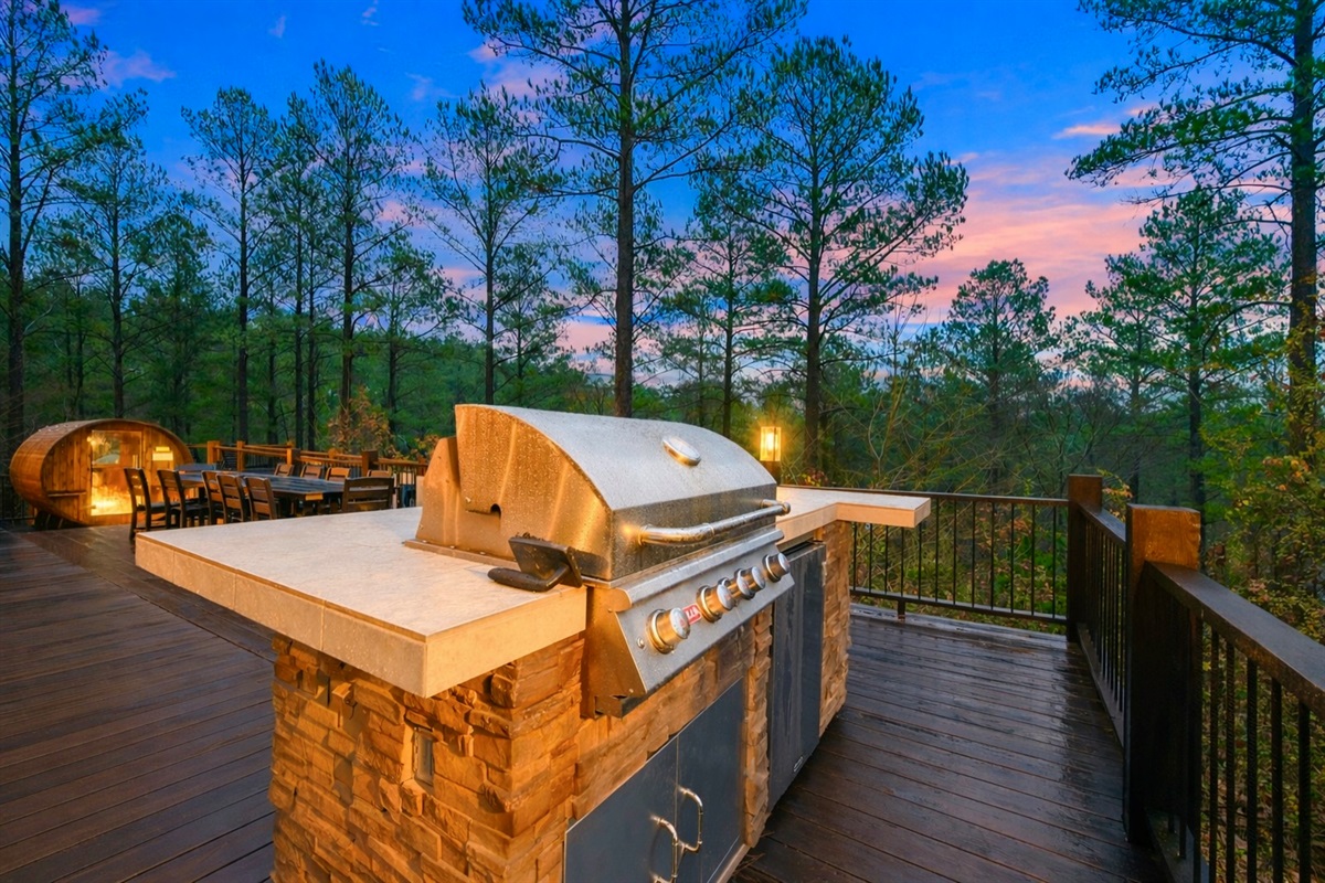 Outdoor kitchen including large grill, side burner and refrigerator. 