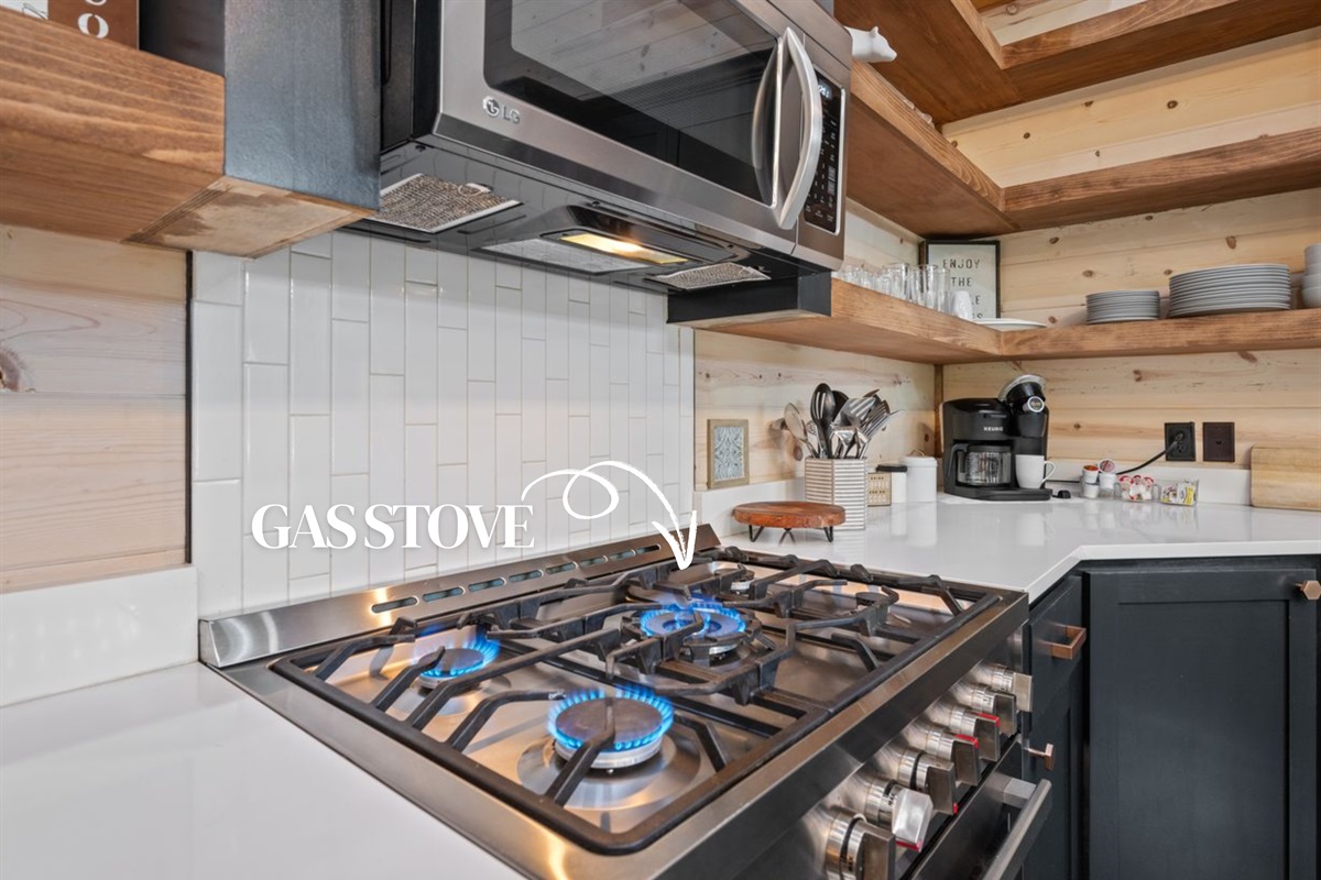 Fully equipped kitchen with modern appliances, open shelving, and plenty of prep space.