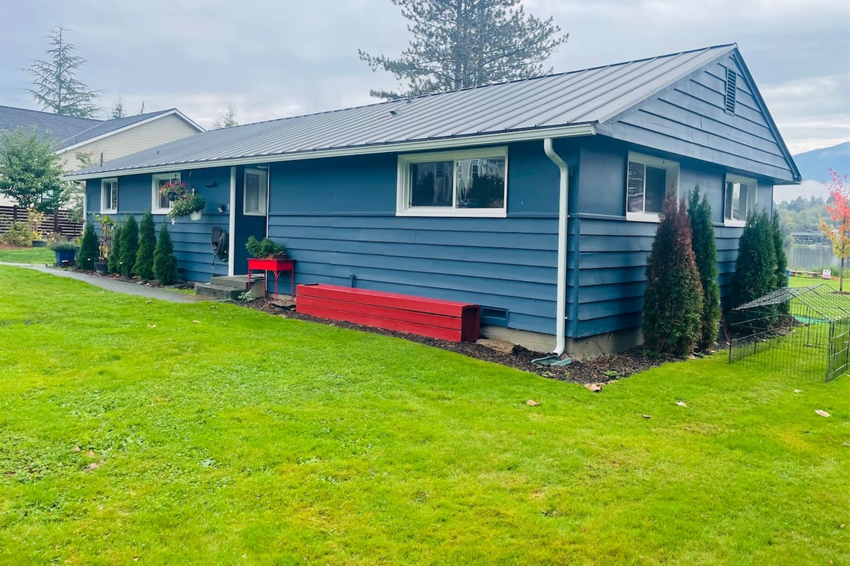 A single-level lakeside home with blue walls and red accents, blending charm and calm in a welcoming setting.