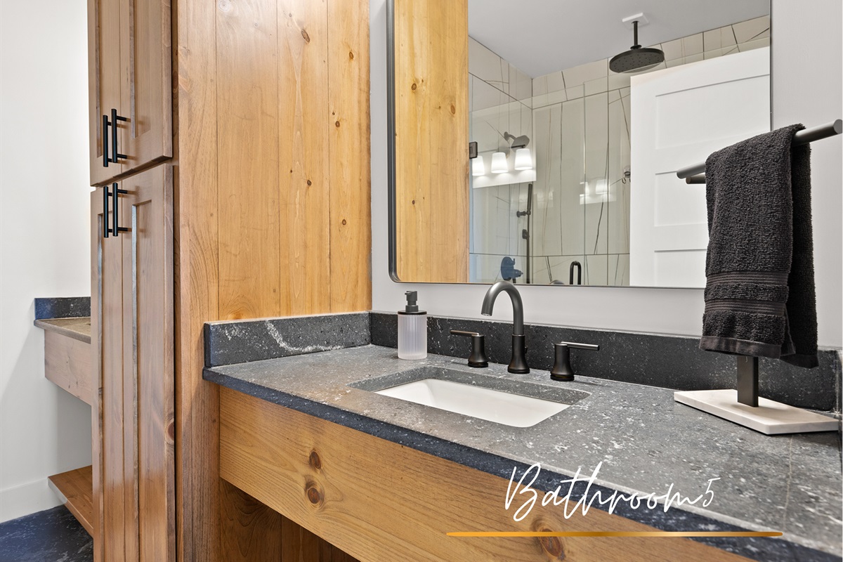 Luxe double sink ensuite bath with walk-in shower located downstairs in the fifth bedroom.
