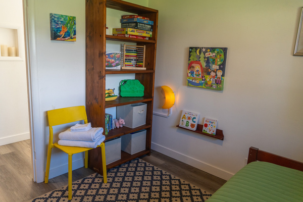 A playful corner filled with books, toys, board games, and puzzles creates a welcoming space where kids can explore, imagine, and enjoy hours of fun.