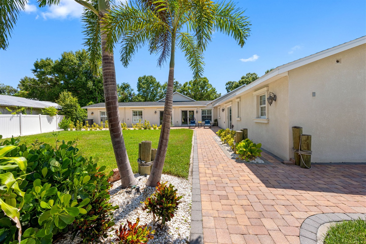 Brick walkways lead you through manicured gardens and open lawn areas, creating a resort-like atmosphere right in your backyard.