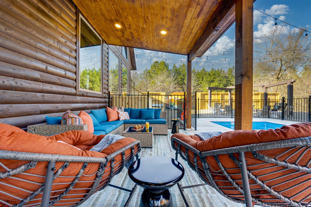 Outdoor Lounge: Unwind in vibrant seating with pool views and twinkling lights overhead!