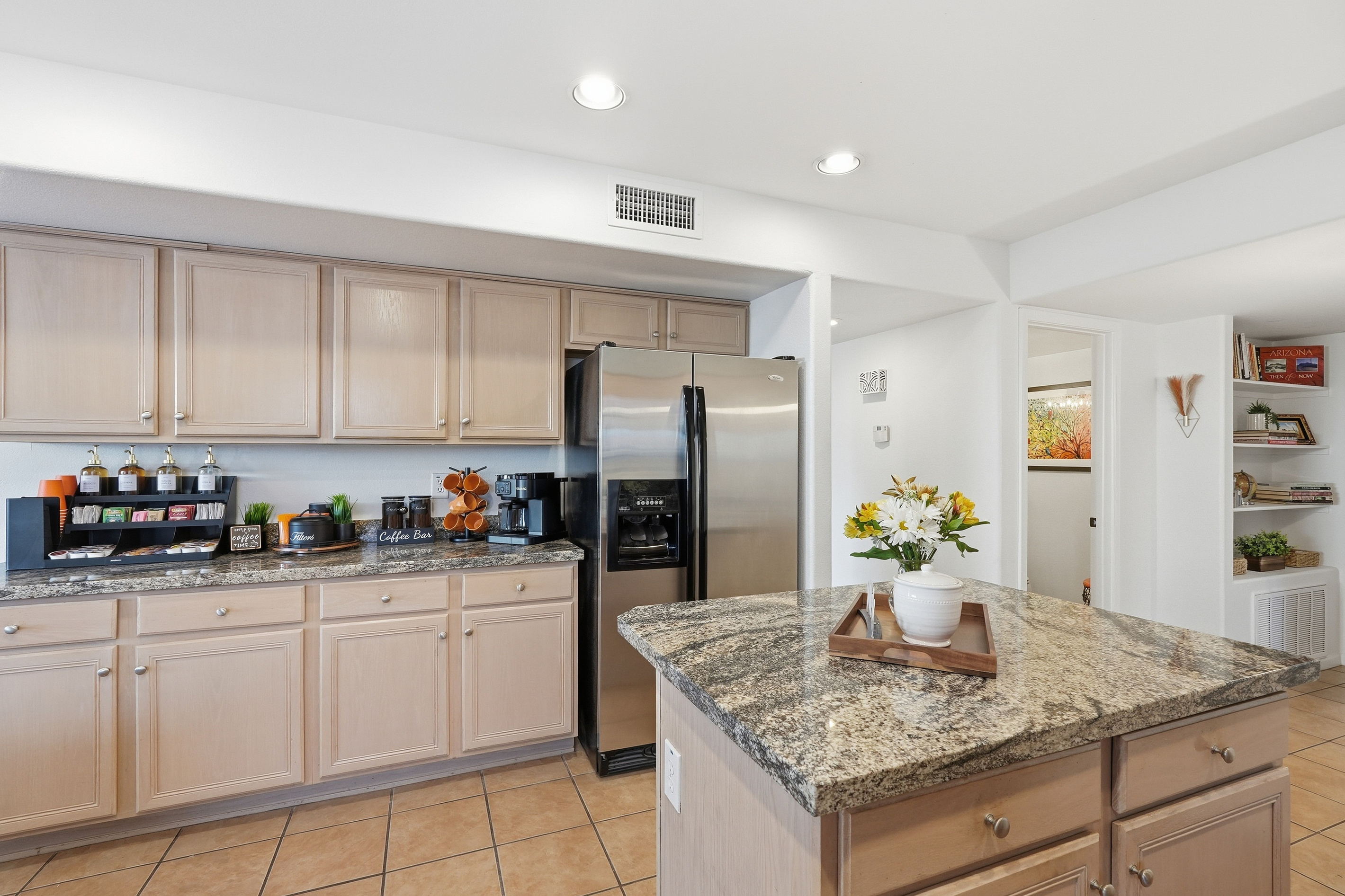 Kitchen sink area with granite counters, dishwasher, refrigerator, and coffee area section.