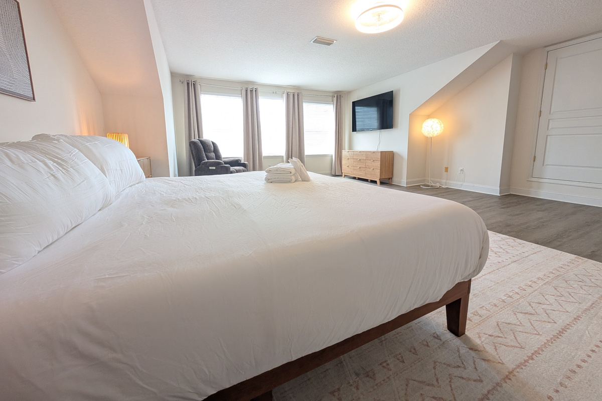 Spacious primary bedroom with a comfortable king bed, TV, and plenty of room to unwind.