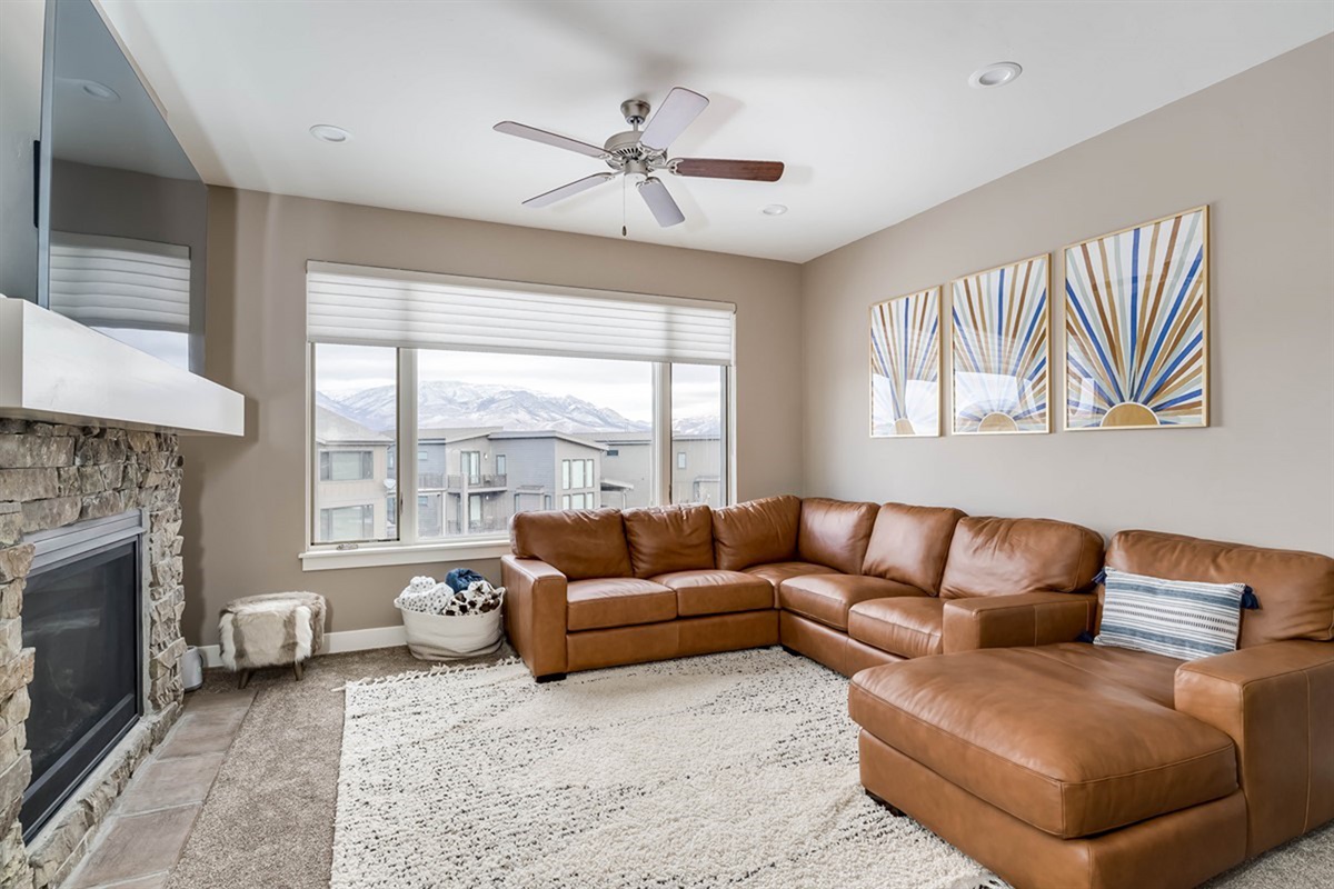 Sun-filled living room with cozy fireplace and expansive windows