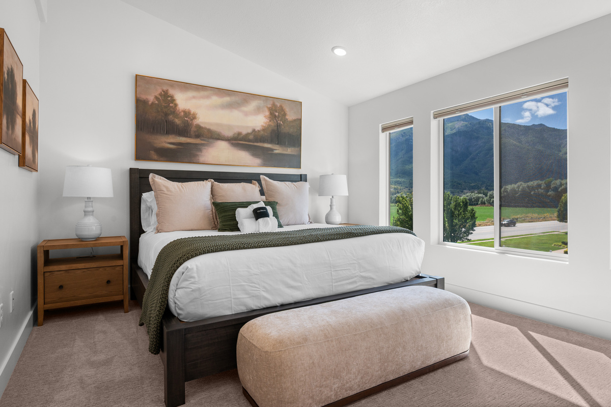 A spacious bedroom with beautiful natural light and mountain views just outside the window.