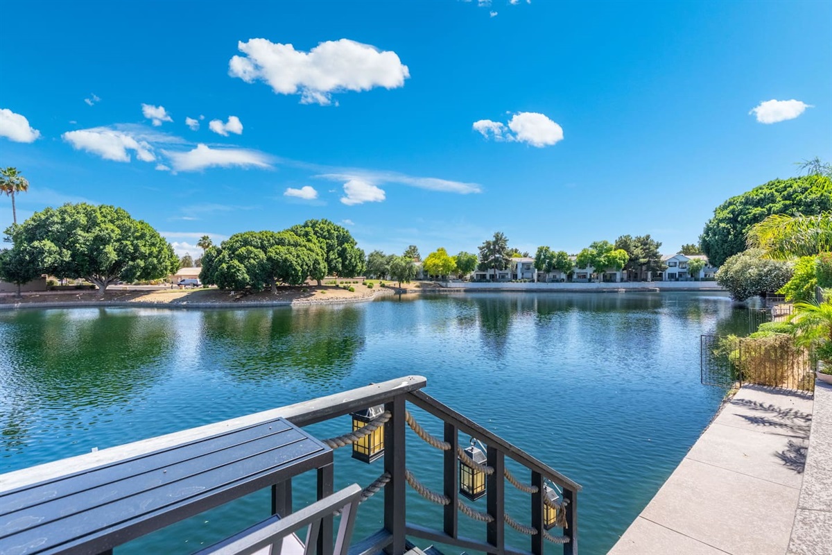 Step down to the dock and take in the full sweep of the lake — a serene, palm-lined panorama that feels a world away from the everyday.
