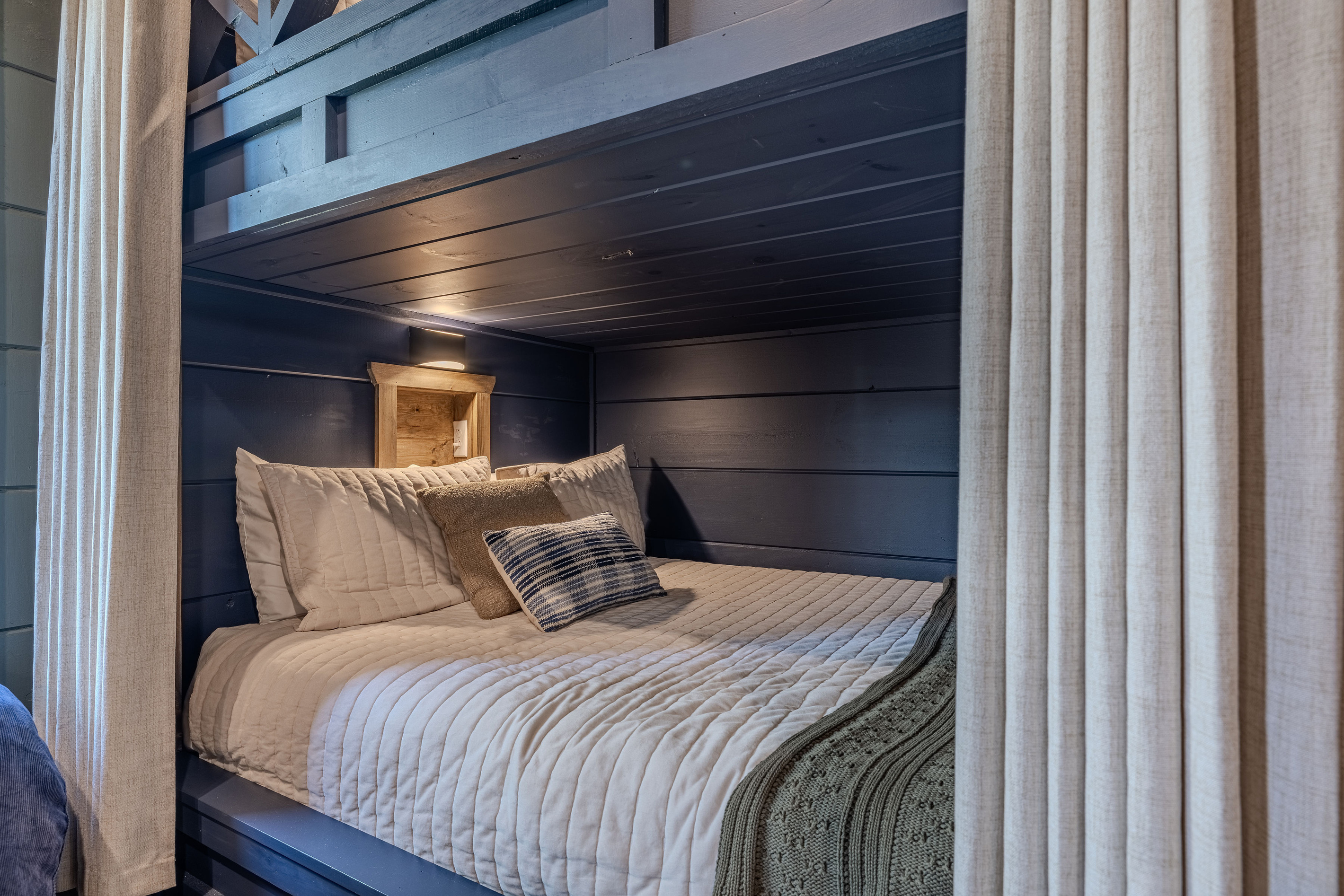 Built-in Queen bunks with individual lights, outlets and phone shelves adds another flexible sleeping option.