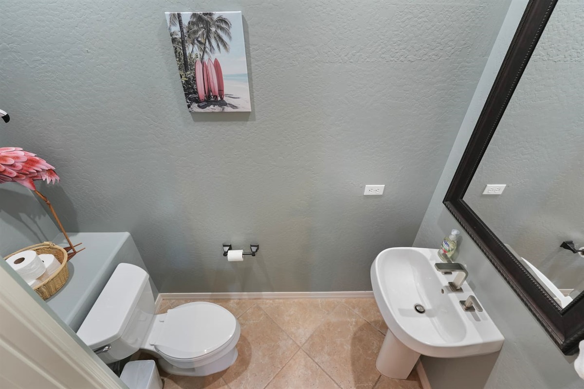 Convenient half bathroom with a modern pedestal sink, fresh finishes, and thoughtful touches—perfectly located for easy access during your stay.