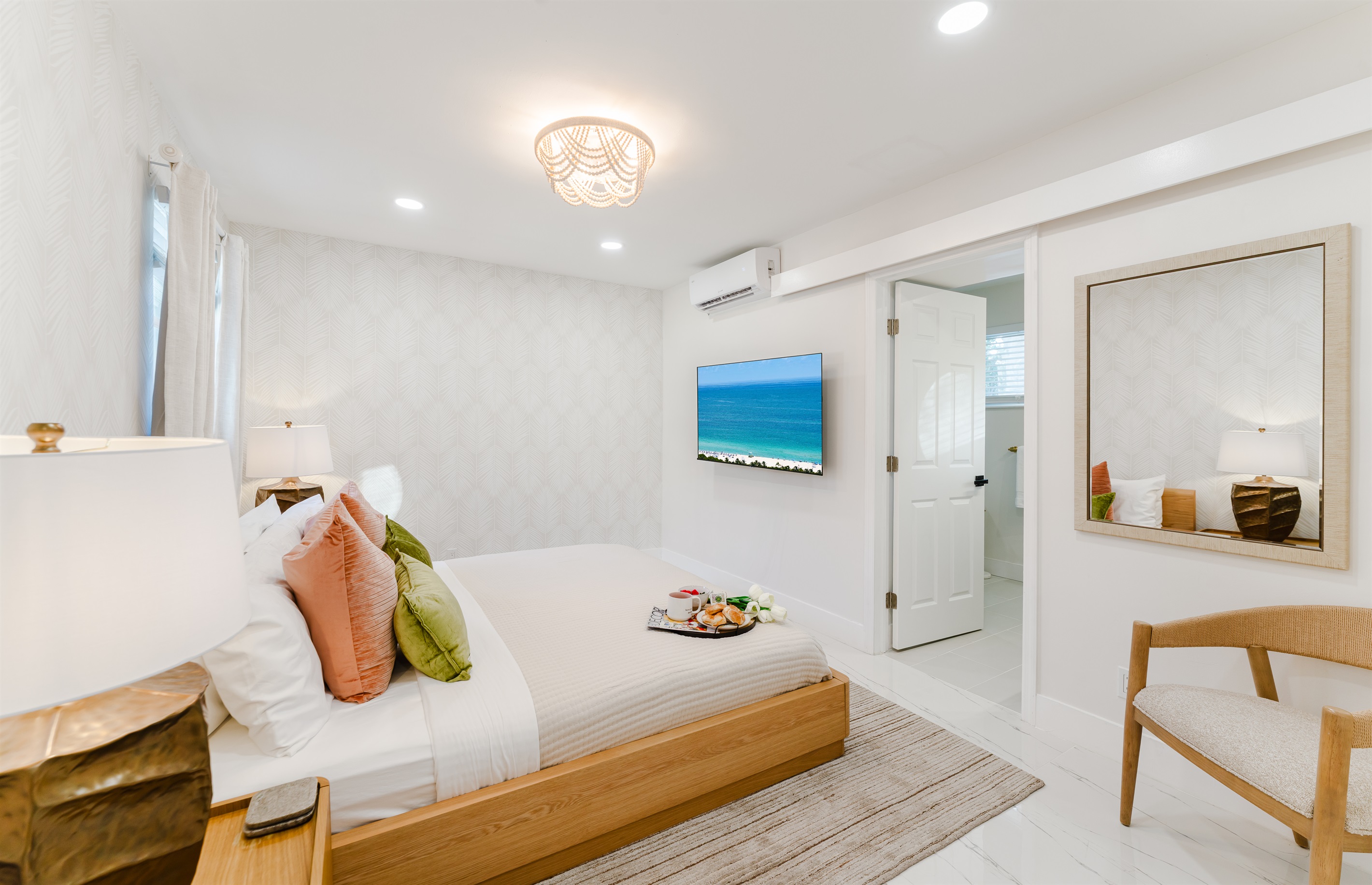 Primary king suite designed for rest and privacy, featuring fresh cotton linens, a Smart TV, and serene Palm Beach–inspired finishes. Includes a walk-in closet and private en-suite bathroom for a comfortable, hotel-style stay.