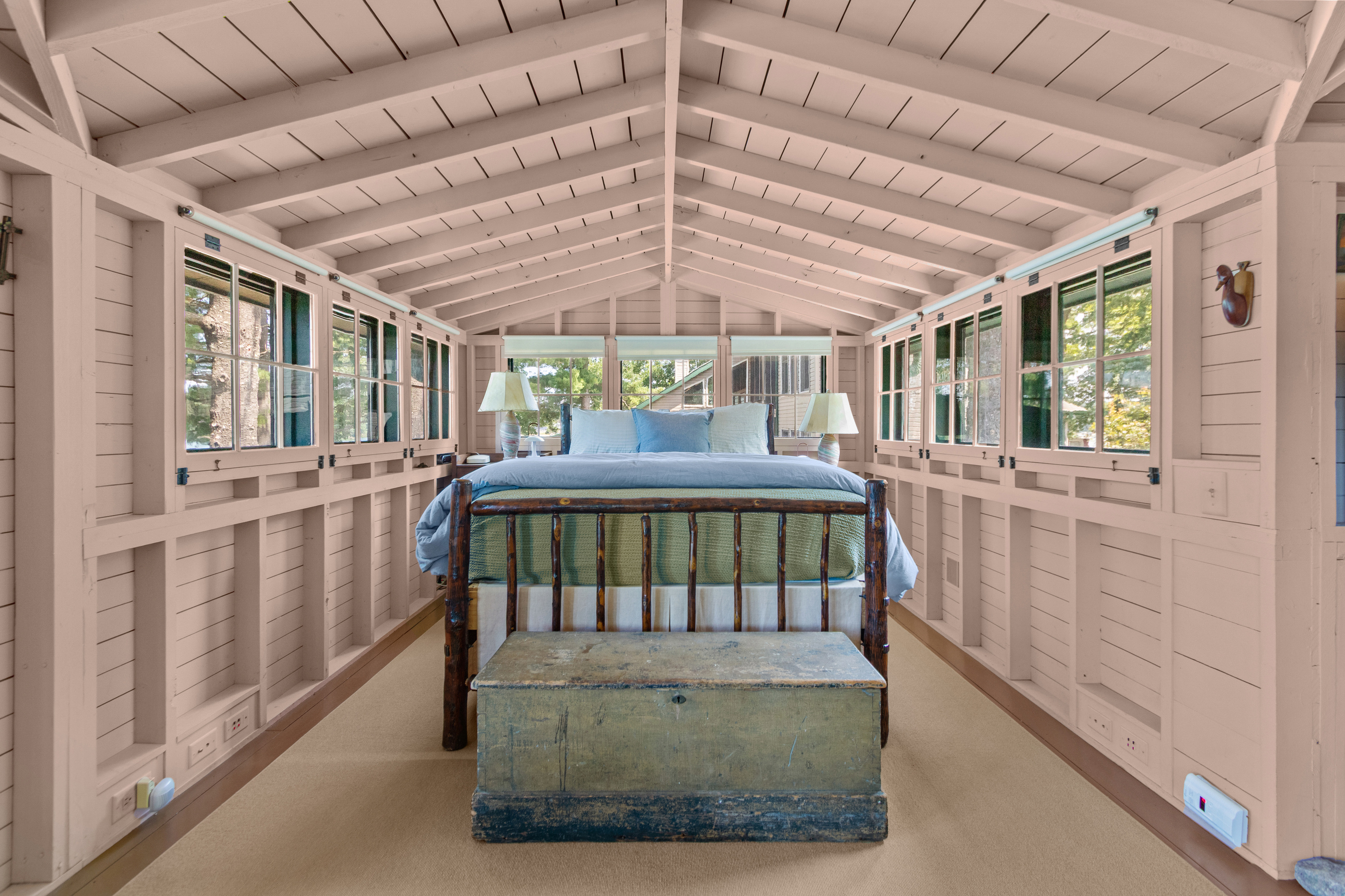 Wake up surrounded by windows and cottage charm in this cozy queen bed, tucked into the spacious upper-level sleeping area.