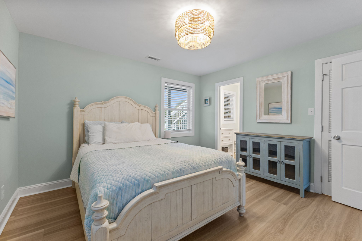 Wake up refreshed in this serene main-level bedroom, styled with soft coastal tones and a relaxed beachside feel