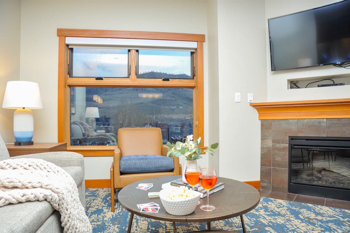 Open living room with TV, fireplace, lake view and with pull out couch