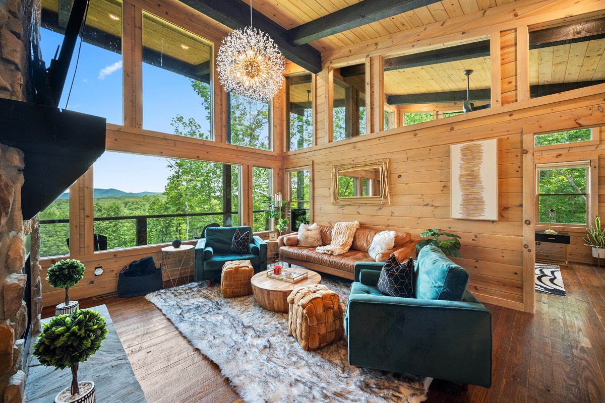 The bright and airy living room is the centerpiece of comfort, with floor-to-ceiling windows that bring the stunning natural surroundings indoors.