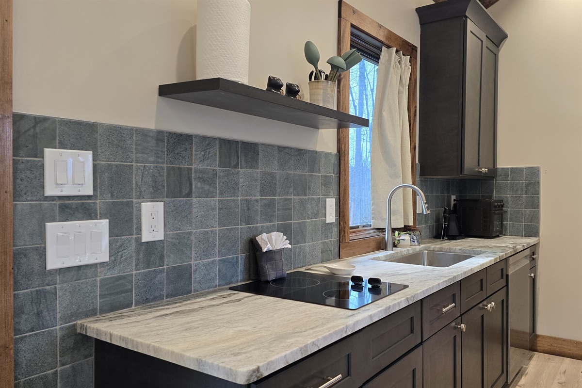 Kitchen with 2 burner cooktop and full-sized dishwasher with custom granite countertop