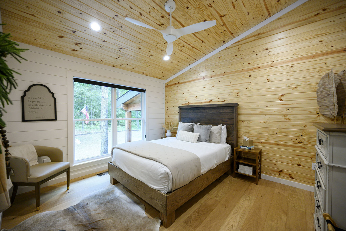 A beautifully appointed queen bedroom featuring luxury design, high-end linens, and peaceful forest views.