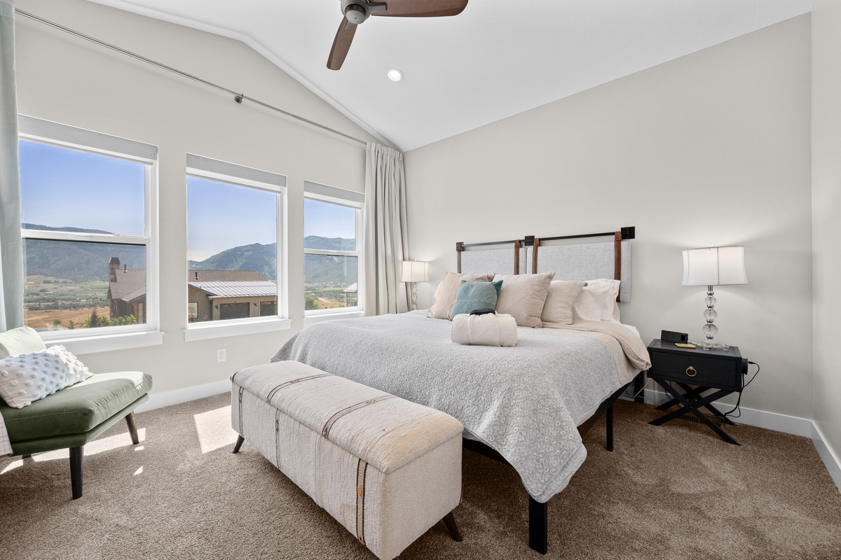 Spacious primary suite featuring a plush king bed, soaring ceilings, and beautiful mountain views to wake up to each morning.