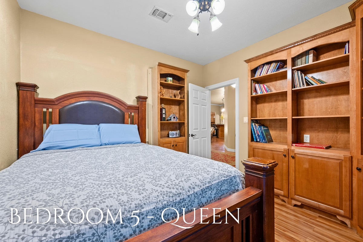 Bedroom 5 with queen bed and built-in shelving.