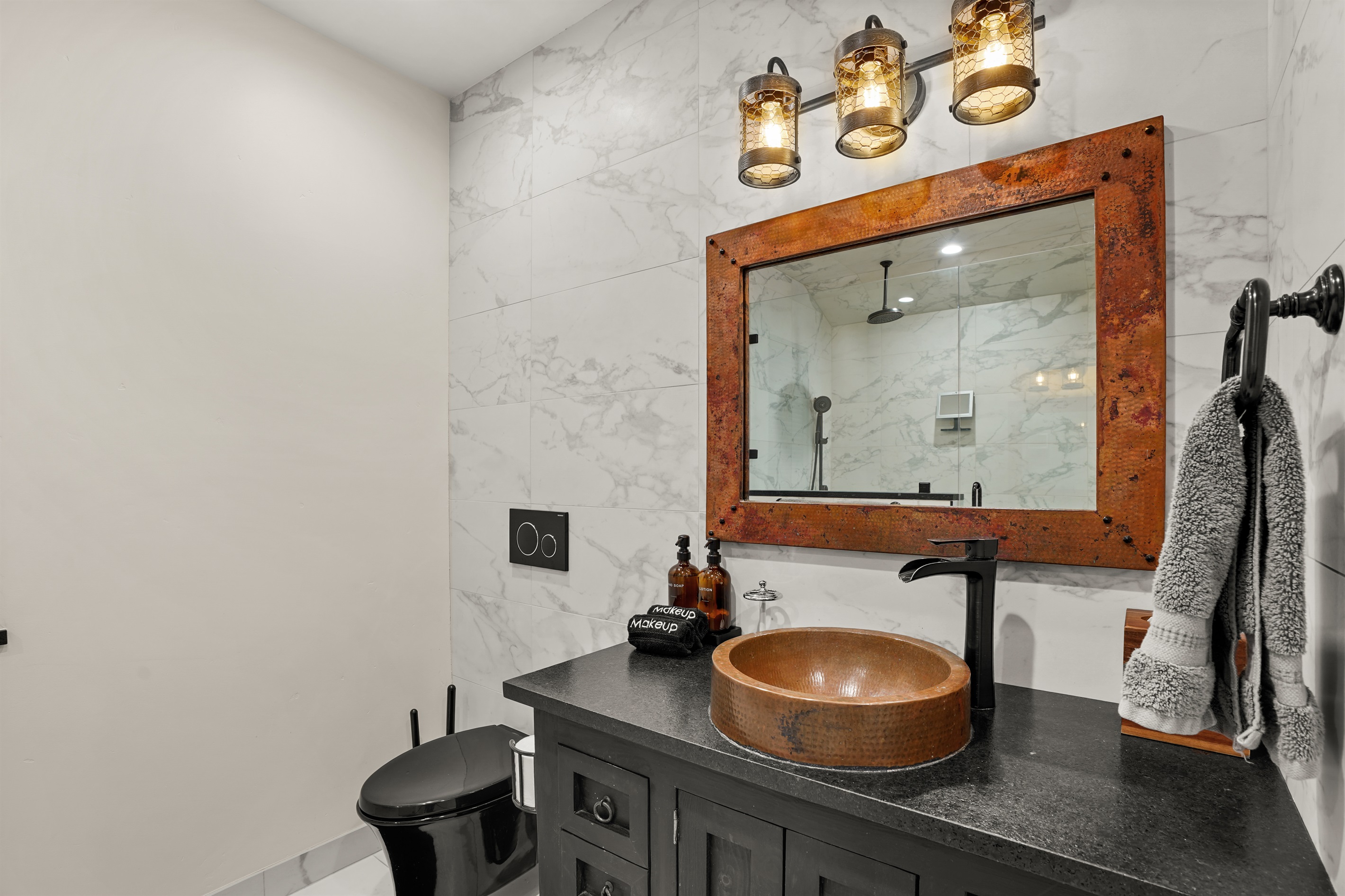 Bathroom with standing shower, toiletries, and bath linens provided