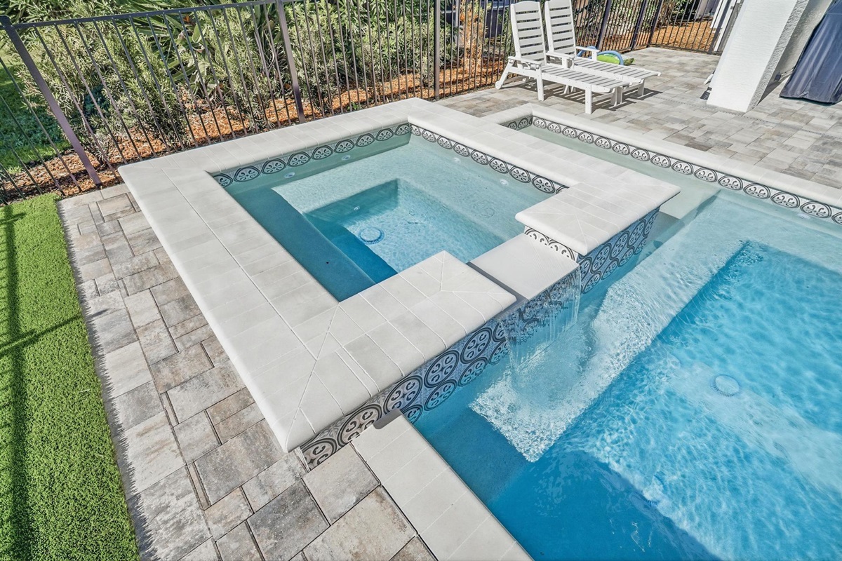 Sink into the bubbling spa while the spillway whispers into the pool, then stretch out on the loungers with a cold drink and zero agenda—your own private courtyard retreat for lazy afternoons and starry-night soaks.
