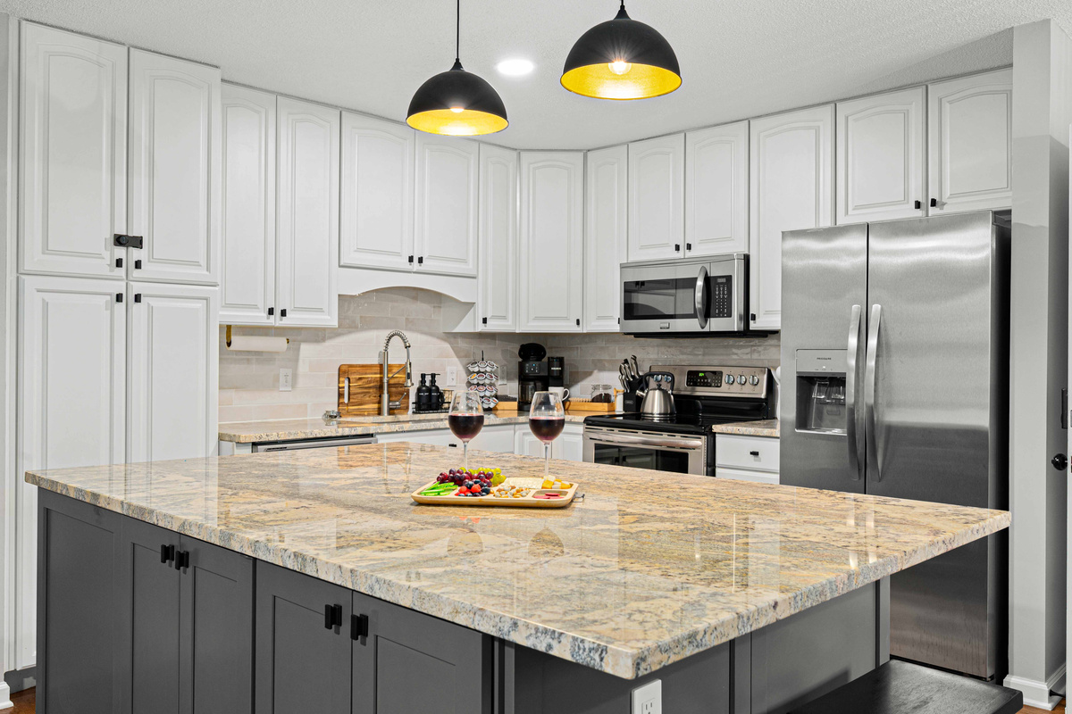 Gourmet Kitchen: Modern elegance with granite island and chic lighting — perfect for culinary adventures!