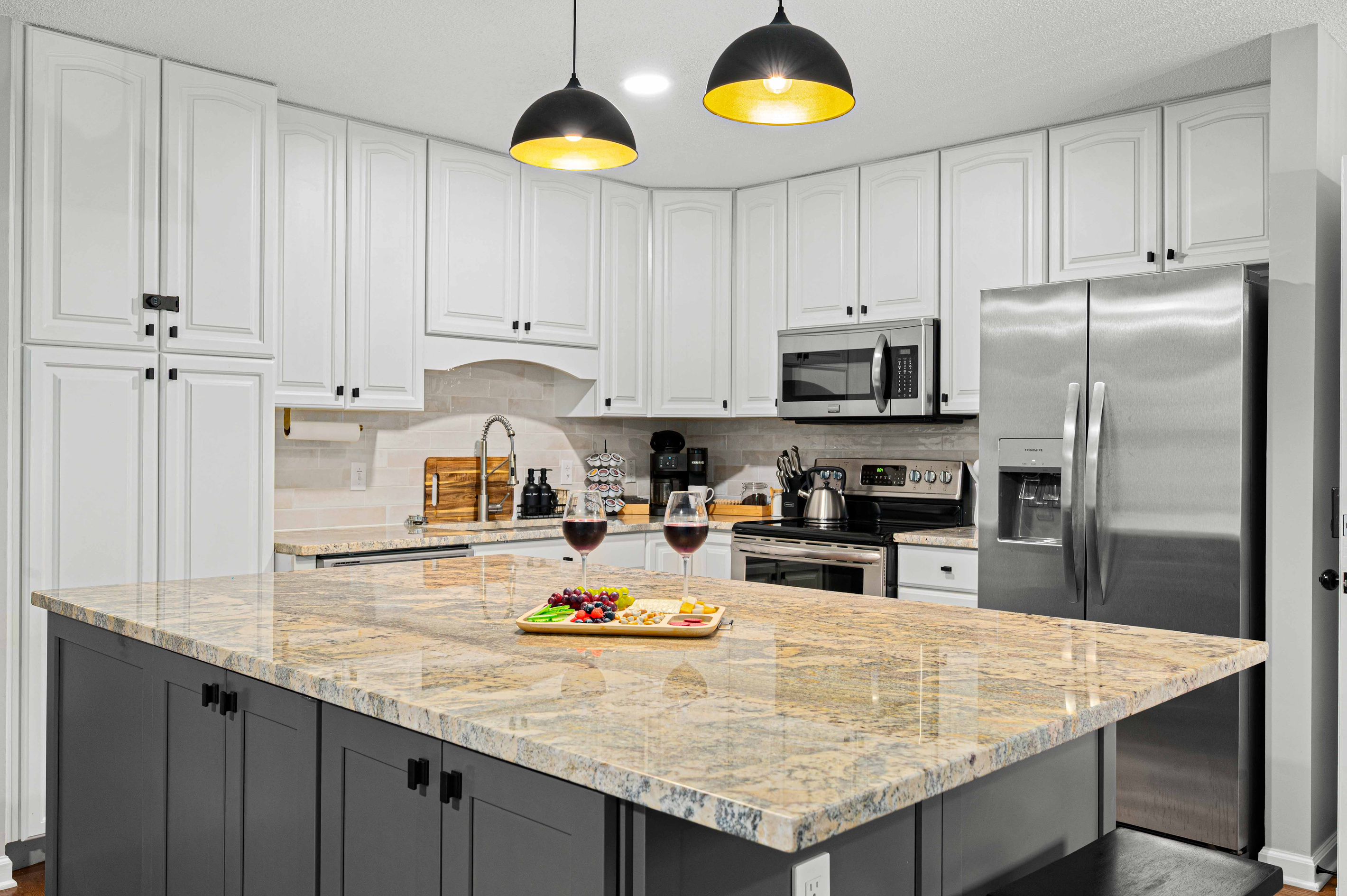 Gourmet Kitchen: Modern elegance with granite island and chic lighting — perfect for culinary adventures!