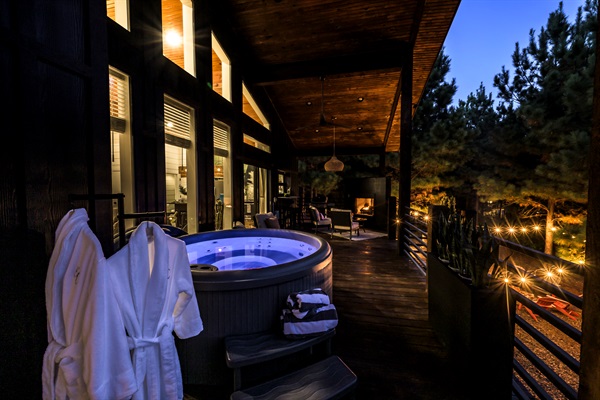 Evenings don’t get better than this — soak in the hot tub, sip wine, and watch the forest glow under string lights.