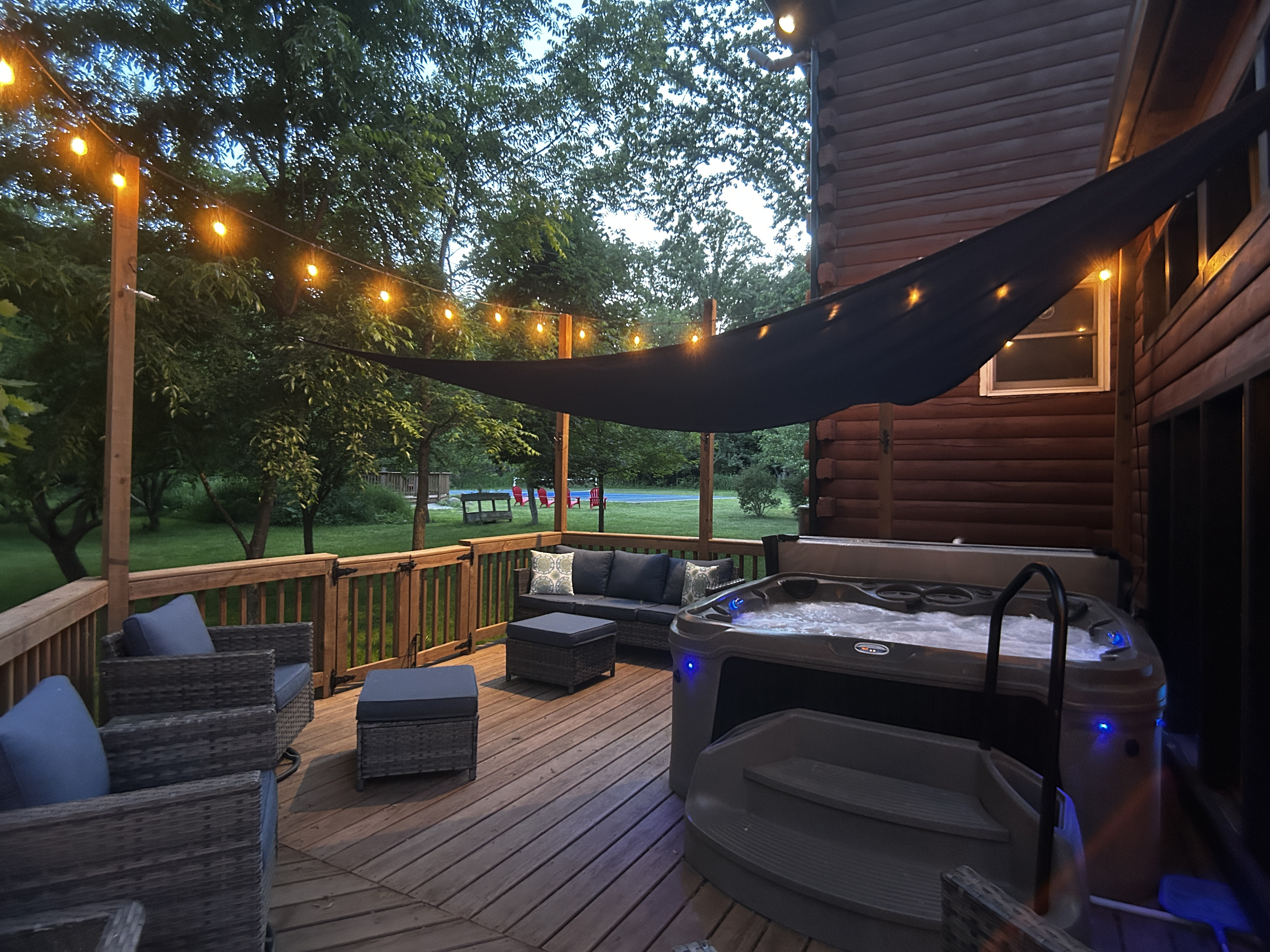 Seating for 7 by the hot tub. The shade sail is installed over the hot tub in warmer months.
