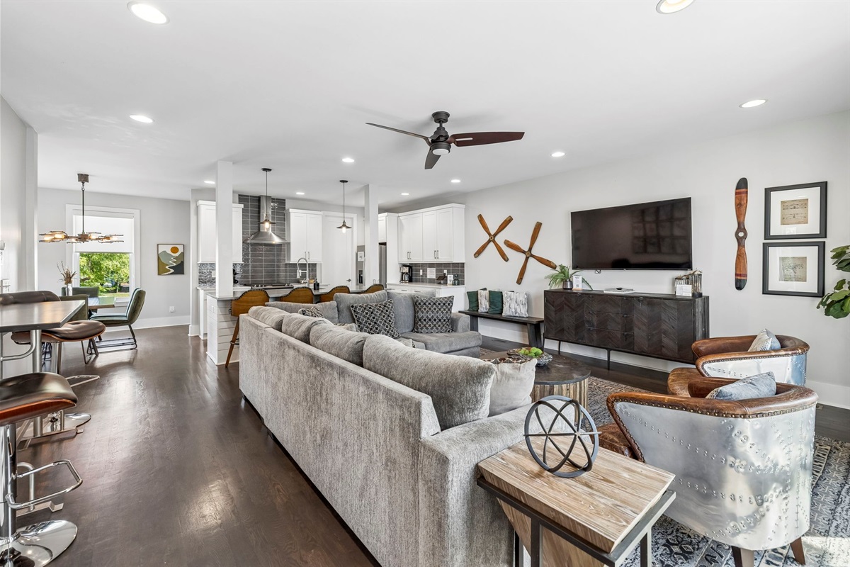 Sleek leather armchairs with metal rivet accents add vintage aviation inspired character - Polished metallic backrests & rich brown leather bring texture & style to the space - Positioned perfectly for conversation or TV viewing in the living area