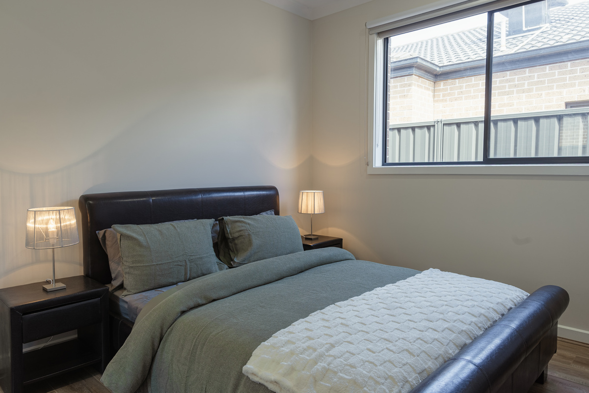 This bedroom at Willows Stays Holiday gives guests a calm sleeping space with bedside lamps, soft bedding and natural light from the window.
