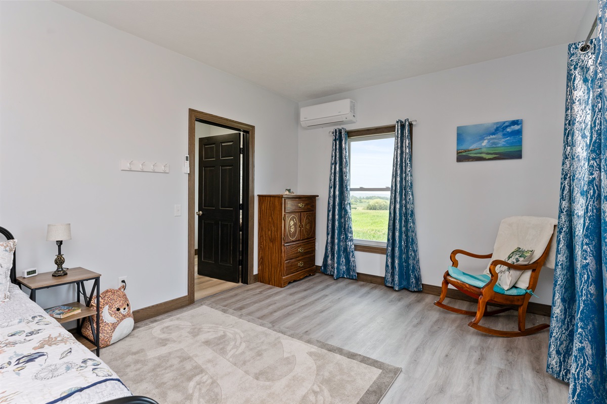 Spacious queen bedroom with large windows, elegant décor, and peaceful country views. Bedroom #3