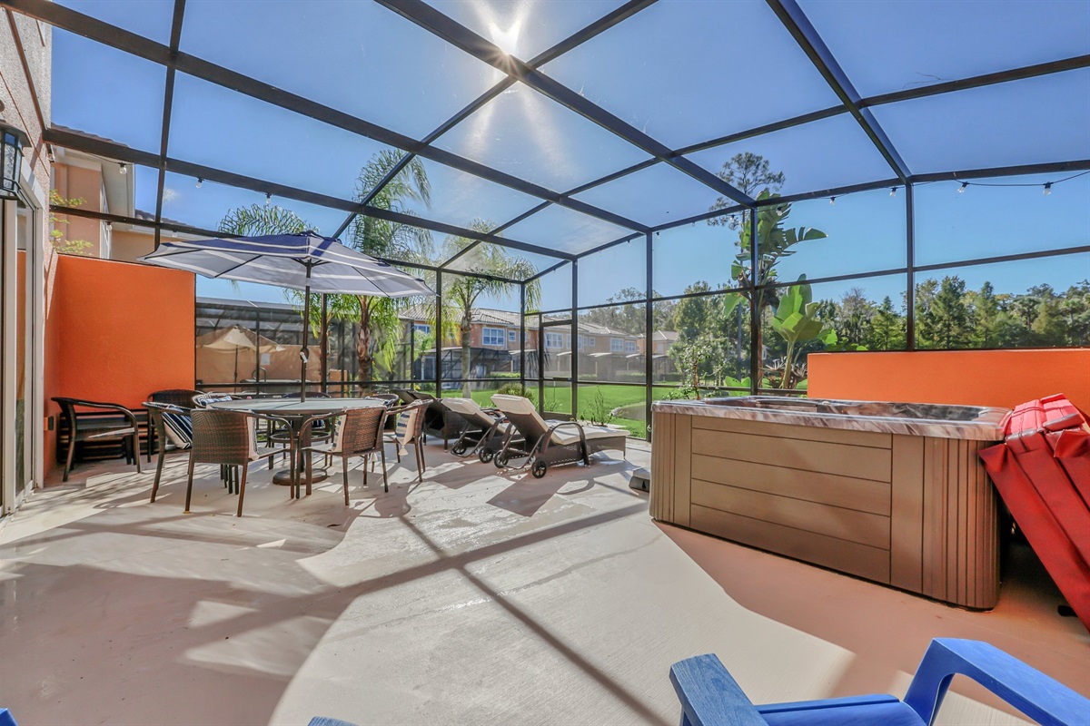 Private covered lanai with seating area, hot tub and lounge chairs