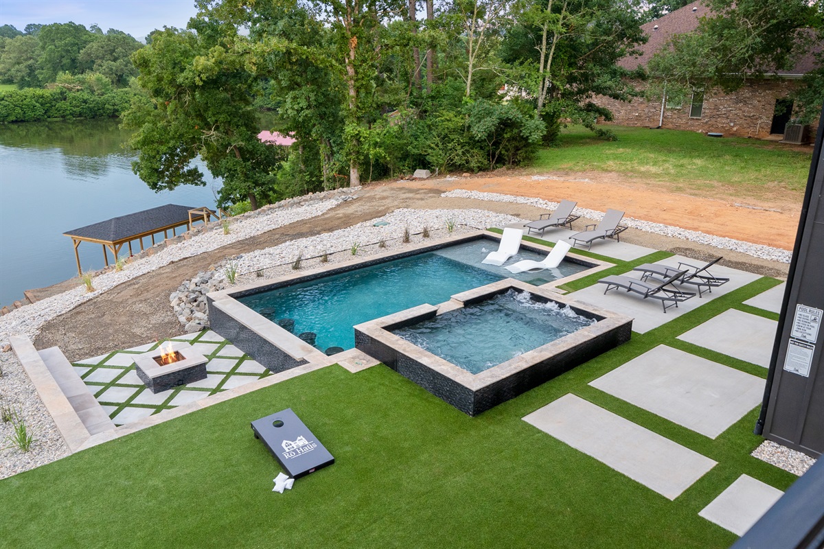 The pool area offers the ultimate outdoor experience, complete with a fire pit and cornhole game.