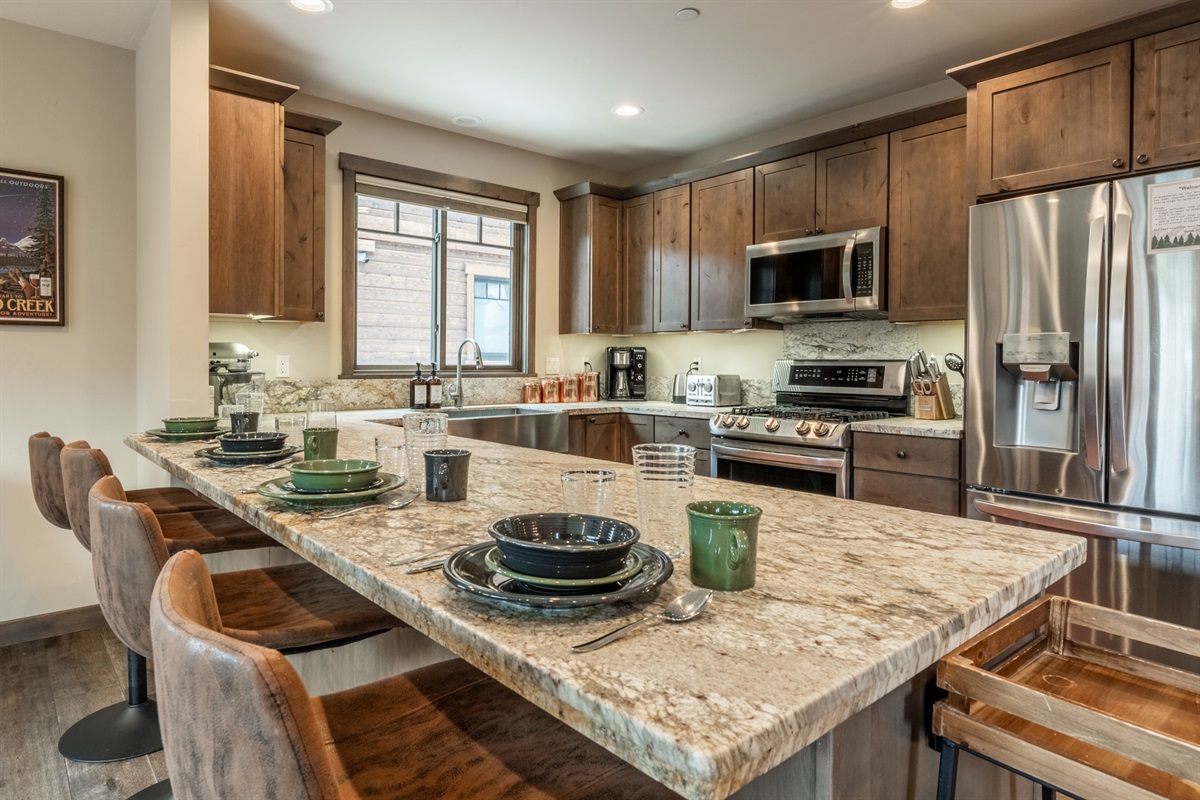 Handcrafted metal bar stools add texture and craftsmanship to this mountain-modern space.
