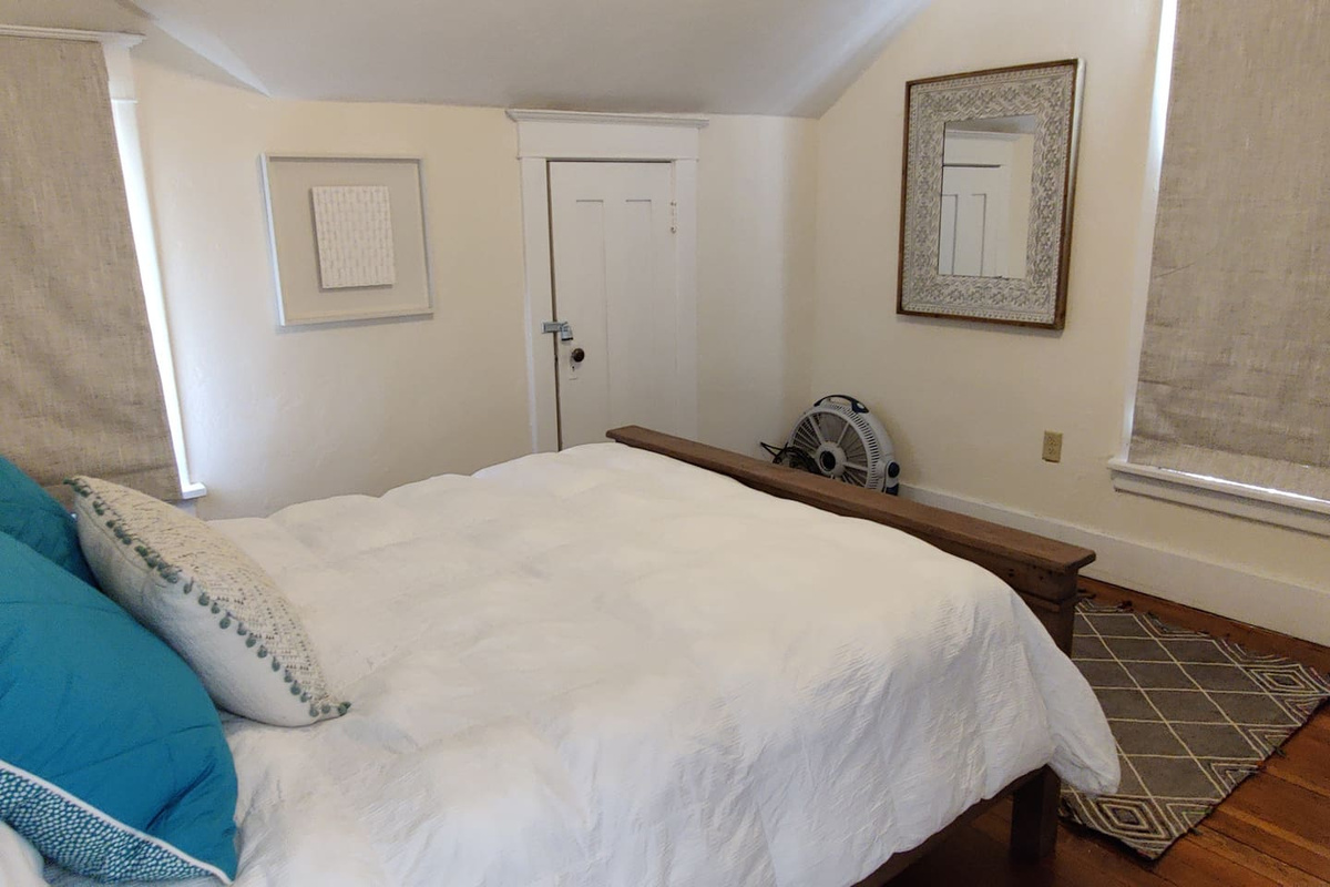 Second-floor bedroom with queen mattress and stylish bedding.