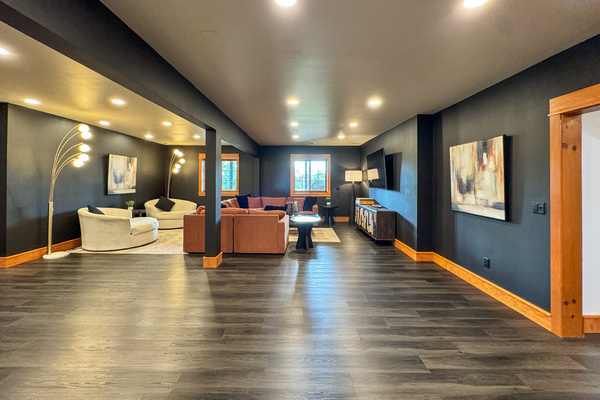 Downstairs living area with multiple seating areas and a large TV.