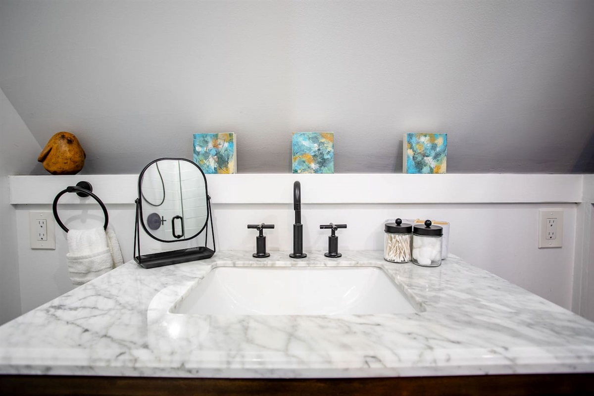 A bathroom sink paired with a small, simple mirror above it, creating a minimalist and functional space that’s both stylish and practical.