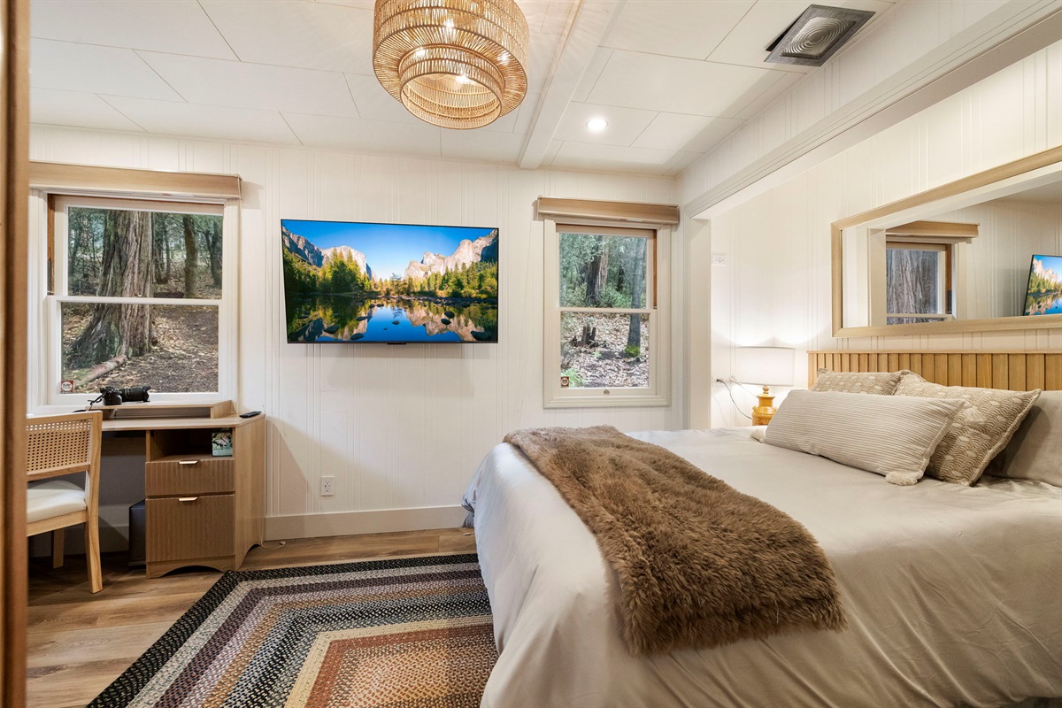 Master bedroom with a fandalier, queen memory foam mattress and separate work/relax area within the room. A smart TV with a HDMI cable and hookups is included as well.