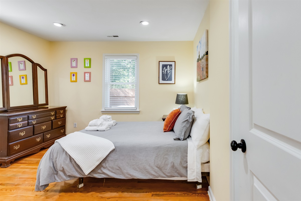 Upstairs Queen Bedroom 2: Bright, inviting space with warm decor and a view of tranquil green outdoors!